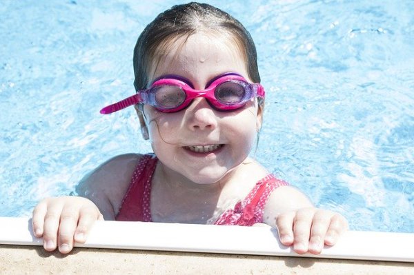 Kind mit Taucherbrille im Pool eines Kinderhotels
