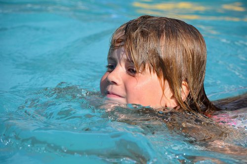 Kind im Schwimmbad eines Familienhotels in Österreich